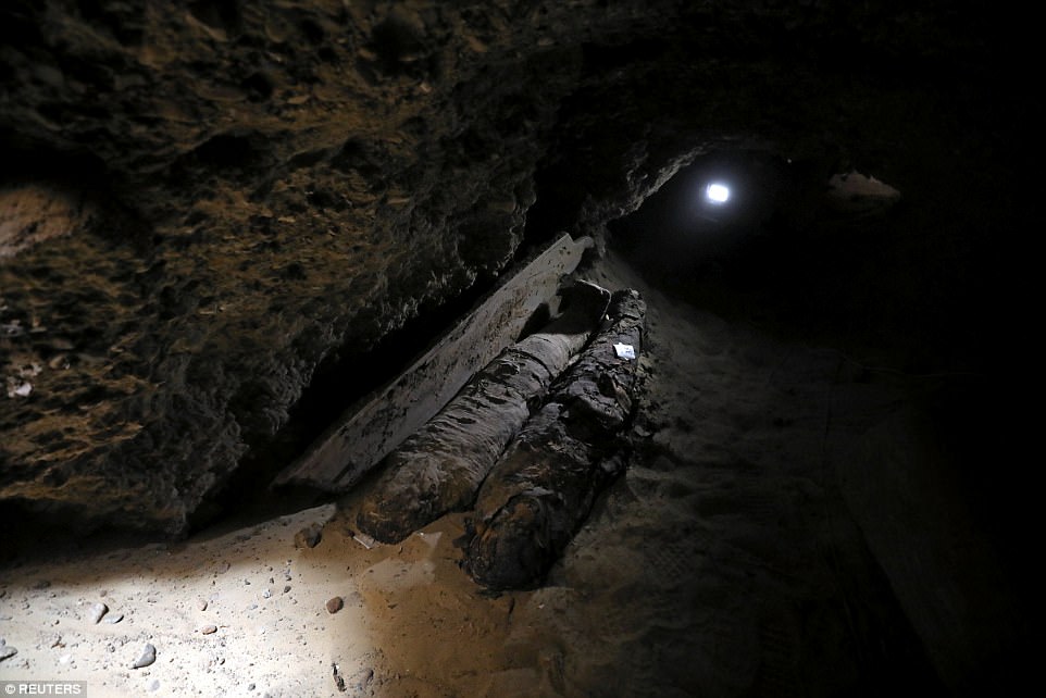 Light shines into one of the burial site's many tunnels, where two mummies can be seen.