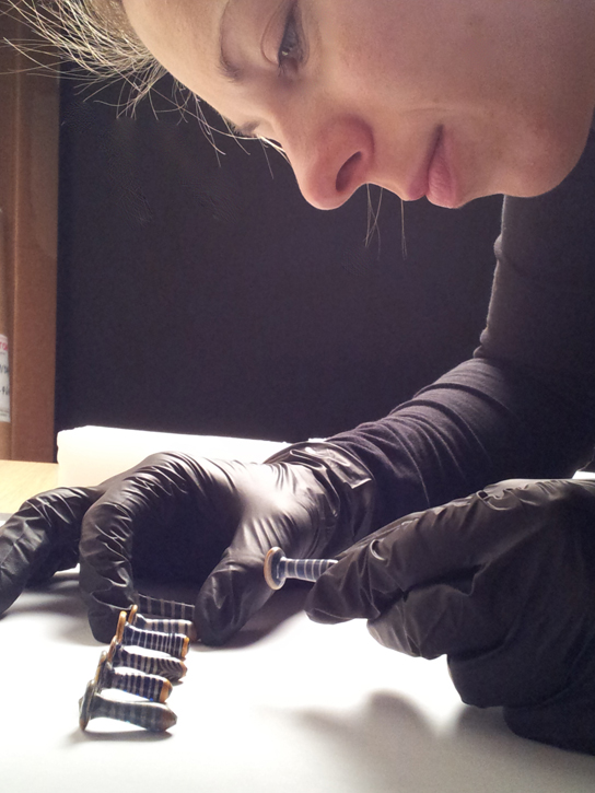 Anna hodgkinson inspecting the glass objects